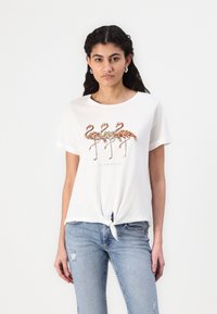Hvid bomulds t-shirt med en bundet frontknude, udsmykket med tre pailette-flamingoer i kobber, guld og rosaguld over teksten "FLAMAZING."