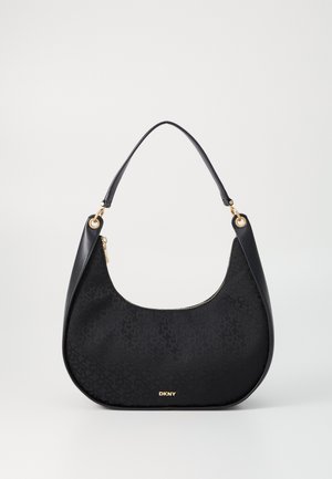 Zwarte DKNY handtas in halvemaanvorm met subtiel logopatroon, gouden ritssluiting en enkele handvatband op een effen witte achtergrond.