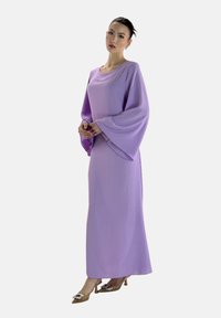 Abito lungo viola con maniche a campana lunghe, realizzato in un tessuto strutturato. Abbinato a mule color cuoio con decorazioni.