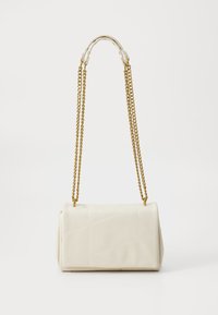 Pequeño bolso rectangular blanco con patrón acolchado y larga correa de cadena dorada colgando sobre un fondo liso.