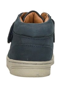 Donkerblauwe leren schoen met een gestructureerde afwerking, voorzien van een zachte bruine binnenvoering, een lage profiel en een grijze rubberen zool.