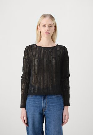 Black knit sweater with a loose fit, long sleeves, and a round neckline. Features a textured pattern and semi-sheer appearance. Paired with blue jeans.