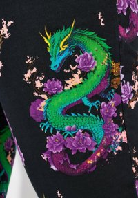 Un tissu noir présente un dragon vert éclatant s'entremêlant avec des fleurs violettes et des accents roses, mettant en valeur un design détaillé et texturé.