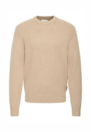 Beige sweater with a round neckline, ribbed cuffs and hem, soft texture, and a slight stretch, featuring a label on the side.