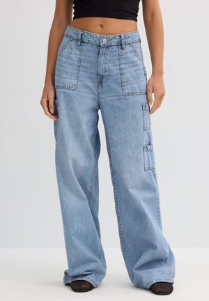 Pantalones cargo de mezclilla azul claro con un corte relajado, que cuentan con dos bolsillos frontales y un bolsillo lateral, destacando costuras en contraste y un cierre de botón.