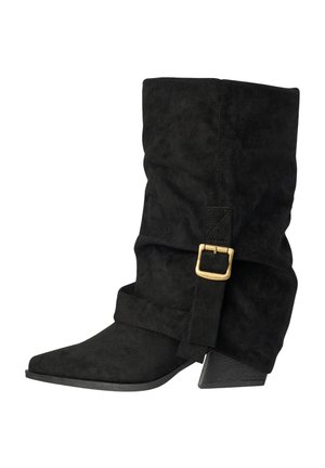 Black suede mid-calf boot with slouchy shaft, pointed toe, stacked angled heel, and decorative gold buckle strap around the ankle.
