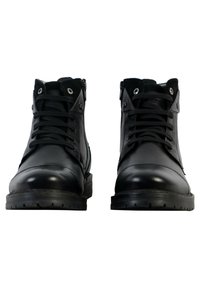 Botas de cuero negro con cordones y cremalleras laterales, que presentan una puntera redonda y acentos texturizados. Suelas de goma duraderas y ojales.