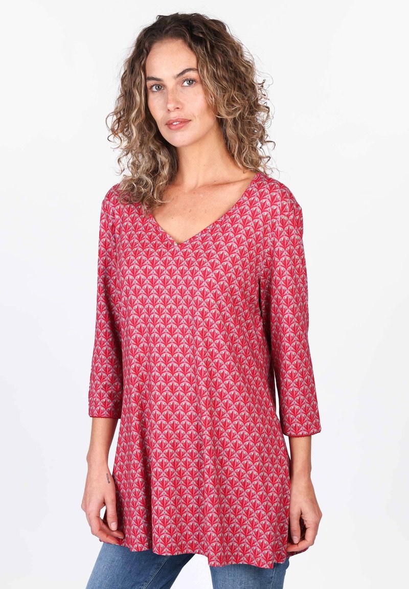 Rotes Tunika-Oberteil mit V-Ausschnitt und drei Viertel-Ärmeln, das ein wiederholendes geometrisches Muster in cremefarbenen und rosa Schattierungen anbietet. Weicher Stoff.