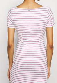 Robe à manches courtes avec un col rond, fabriquée dans un tissu doux arbore des rayures horizontales roses et blanches, avec un subtil éclat.