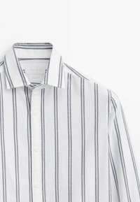 Witte button-up shirt met verticale marineblauwe strepen, voorzien van een klassieke kraag, één borstzak en een zachte katoenen textuur.
