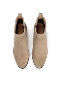Botine din suede bej, cu vârf ascuțit, fermoare laterale și o textură netedă, având un toc mic și o talpă căptușită.