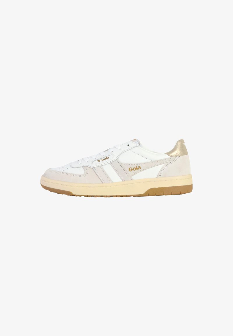 Des chaussures de sport blanches en suède et en cuir, avec des accents dorés sur le talon et une semelle en caoutchouc texturé. Conçues avec un système de laçage.