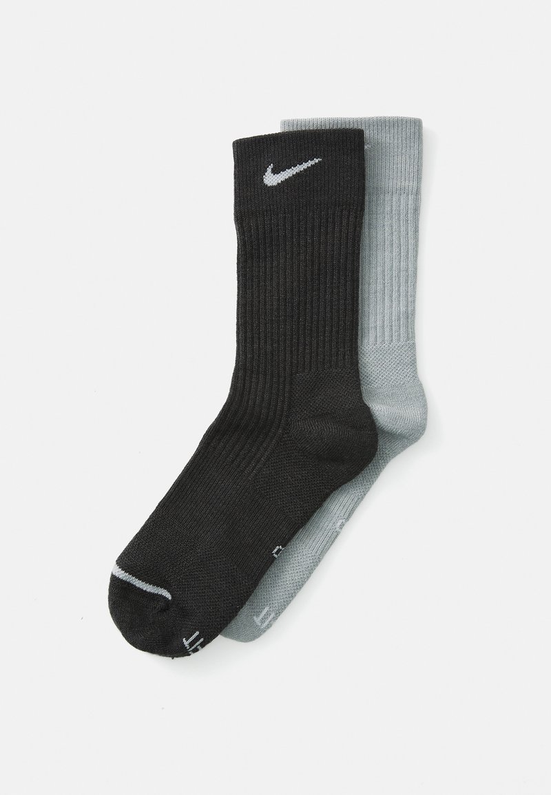Musträpist esinevad mustad ja heleroosad riidest sokid, mille mustal paaril on Nike logo; mõlemal on tugevdatud varbad ja sujuv tekstuur.