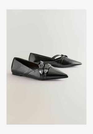 Černé špičaté baleríny s lesklou koženou texturou, které mají dva kovové přezky na pásku přes nárt a nízký podpatek.