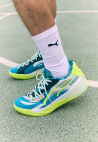 Lightweight athletic shoes in blue, white, and neon green, featuring a textured upper, distinct lacing system, and padded collar.