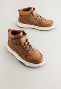 Brązowe sneakersy za kostkę, wykonane z materiałów skórzanych i tekstylnych, z zasuwanym zapięciem, rzepem, eleganckim kształtem i białą gumową podeszwą.