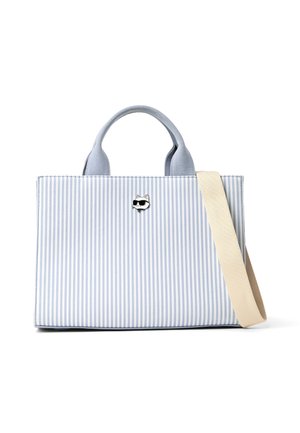 Sac fourre-tout à rayures verticales bleu et blanc avec des anses courtes, une bandoulière beige et une petite épingle en forme de visage de chat portant des lunettes de soleil à l'avant.