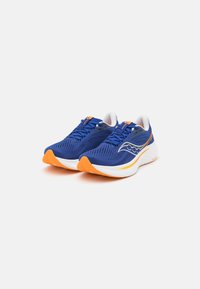Baskets de sport bleues avec une tige en mesh respirant, accents oranges sur la semelle extérieure et une semelle intermédiaire blanche. Présente un design épuré et un système de laçage.