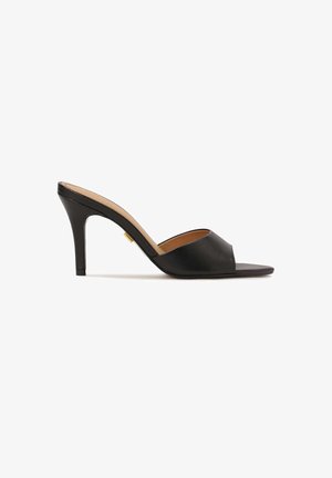 Schwarze offene High-Heel-Mules mit einem glatten Leder-Obermaterial, mandelförmiger Vorderseite und einem eleganten Stiletto-Absatz. Sichtbares Detail in Goldoptik.
