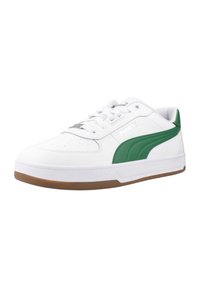 Zapatilla blanca con acentos verdes, hecha de materiales de cuero y sintéticos, suela plana de goma, caja de dedos perforada y detalle del logo en el costado.