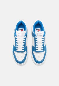Sneaker low-top in denim blu e pelle bianca, con punta perforata, cuciture a contrasto e lacci bianchi. Logo sulla linguetta.