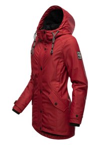 Veste imperméable rouge avec une capuche doublée en polaire noire, des boutons à l'avant, des cordons de serrage gris et des poches latérales. Elle présente un patch logo sur la manche.