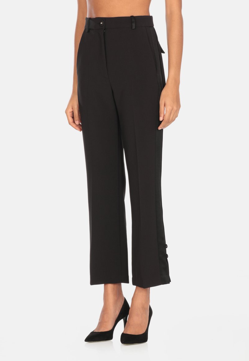 Pantaloni neri su misura con gamba dritta, strisce laterali, tasche frontali e chiusura con bottone in vita. Tessuto morbido e leggero.