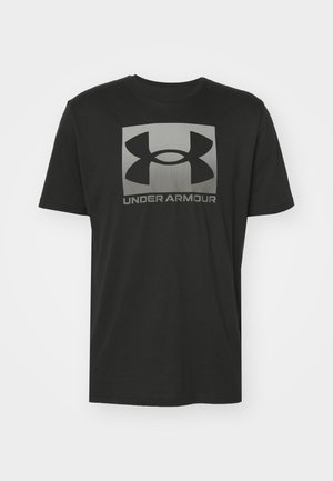 Zwarte katoenen t-shirt met korte mouwen, voorzien van een groot grijs Under Armour-logo op de voorkant, een gladde textuur en een ronde hals.