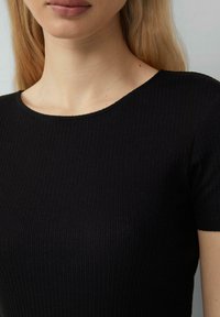 Zwarte geribbelde t-shirt met een ronde halslijn en korte mouwen. De textuur is soepel met verticale lijnen die een aansluitende uitstraling creëren.