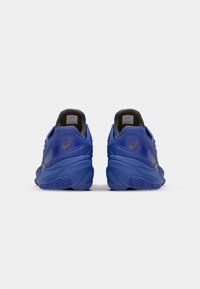 Des chaussures de sport bleues présentent une tige en maille texturée, une semelle extérieure en caoutchouc solide et une semelle rembourrée pour le confort. Accents noirs sur le talon.