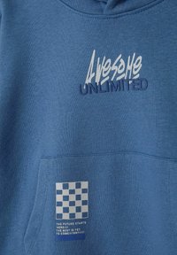 Blå sweatshirt med huva, med strukturerad vit text "AWESOME" och mörkblå text "UNLIMITED". Ett grafiskt rutmönster på fickan.