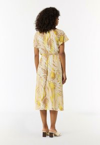 Kurzes Midi-Kleid aus leichtem Stoff, mit einem blassen gelben und beigen Blattmuster, tailliertem Bund und fließender Silhouette.