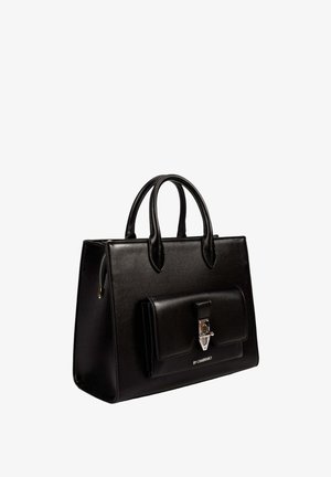 Sac à main en cuir noir avec deux poignées, poche avant à rabat avec fermoir argenté, et logo "BY-CHABRAND" sous la poche.