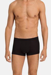 Černé boxerky vyrobené z hladkého, strečového materiálu. Mají přiléhavý design a elastický pas s centrální kapsou.