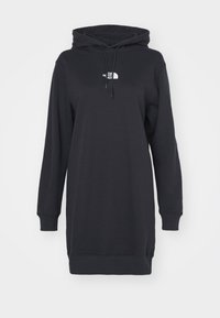 Svart huvtröjdress i mjukt tyg, med kenguruficka, långa ärmar och en liten vit logotyp på bröstet.