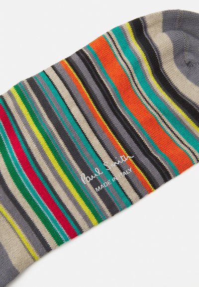 Striped sock featuring horizontal patterns in gray, green, orange, red, and yellow. Material appears soft and knitted, with logo detail.