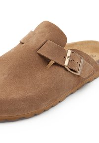 Sandale slip-on en daim marron avec une sangle à boucle, tige texturée, bout arrondi et semelle en caoutchouc beige. Design simple et fonctionnel.
