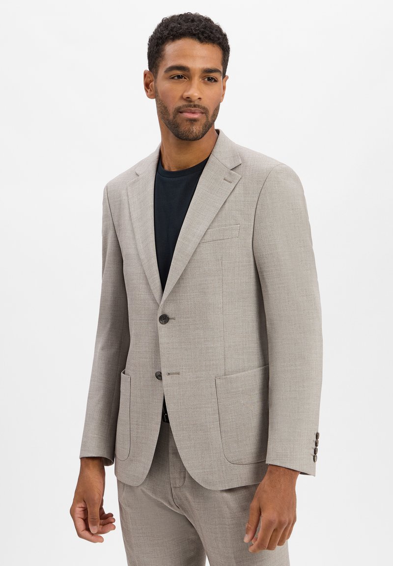 Lichtgrijze blazer van een getextureerde stof met twee knopen, met gekartelde revers en twee voorzakken, gecombineerd met een zwart shirt.