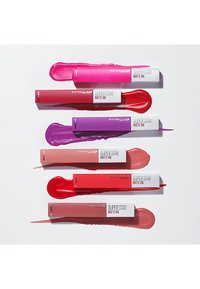 Six rouges à lèvres liquides Maybelline Super Stay Matte Ink affichés horizontalement, présentant des teintes variées : rose, rouge, violet et nude avec un logo blanc.