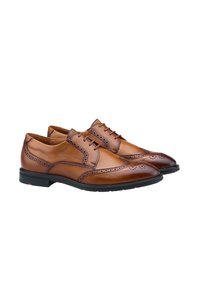 Heren leren dresschoenen in bruin met een gladde afwerking, brogue-details en een zwarte rubberen zool. Voorzien van een spitse neus en vetersluiting met vijf oogjes.