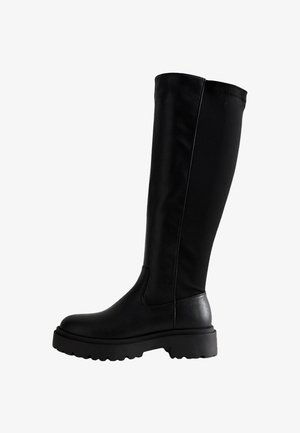 Schwarze Stiefel bis zum Knie mit glattem Lederoberteil, elastischem Rückenteil, dicker Sohle und runder Zehenform.