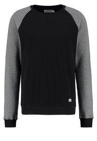 Sudadera negra con mangas raglán grises, cuello redondo, puños y dobladillo acanalados. Presenta un pequeño logo en la parte inferior izquierda.