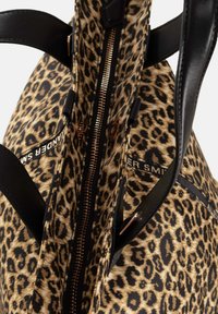 Borsa tote in stampa leopardata realizzata in tessuto con zip metallica, manici in pelle nera e dettagli con marchio all'interno.