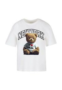 Bílý tričko s grafikou hnědého medvěda s tričkem, na kterém je napsáno "I ❤️ NYC", s textem "NEW YORK" nahoře.