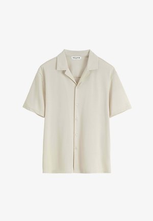 Chemise beige à manches courtes boutonnée, col camp, design minimaliste et étiquette de marque visible à l'intérieur de l'encolure.