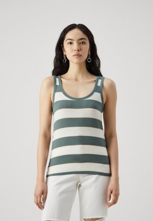 Striped tank top in muted green and white, made of soft fabric, featuring a round neckline and wide straps. Styled with white shorts.