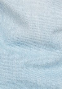 Ljusblå denimtyg med en mjuk struktur och ett subtilt twillvävmönster. Mjuk och något skrynklig utseende.