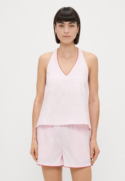 Rosa ärmelloses Oberteil mit V-Ausschnitt und roten Akzenten, kombiniert mit pinken Shorts, die am Saum einen ähnlich gestalteten roten Akzent aufweisen.