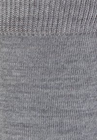 Grau gestrickter Stoff mit gleichmäßiger Textur und gerippten Akzenten. Das Material erscheint weich, hat einen subtilen Glanz und ein konsistentes Muster.