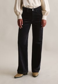 Donkerblauwe corduroy broek met een rechte pijp, voorzien van een vijfzakkenmodel en een metalen knoopsluiting in de taille.